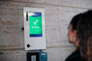 una mujer utiliza un sistema de biometría facial para acceder a un edificio