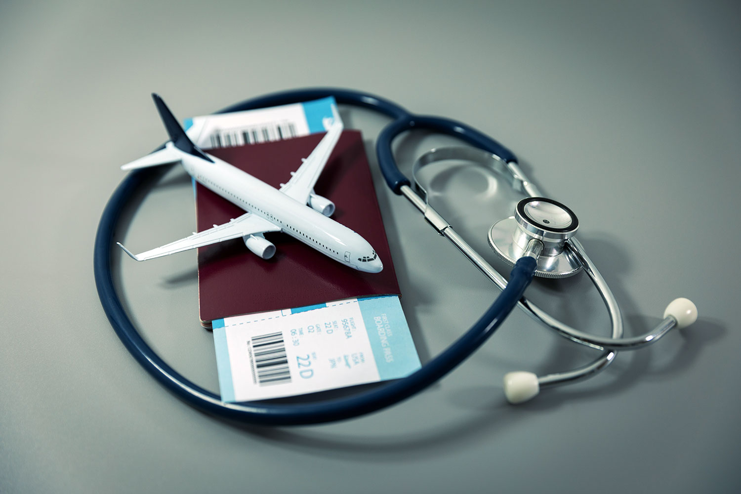 un avión sobre un pasaporte y junto a un endoscopio médico