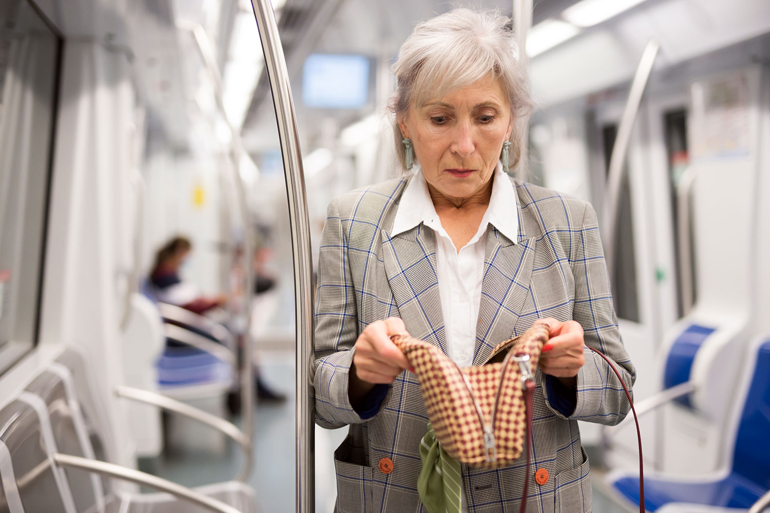 Una mujer comprueba sorprendida que le han hurtado las pertenencias de su bolso en el metro