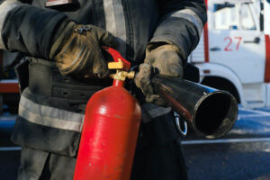 un bombero sostiene un extintor con ambas manos