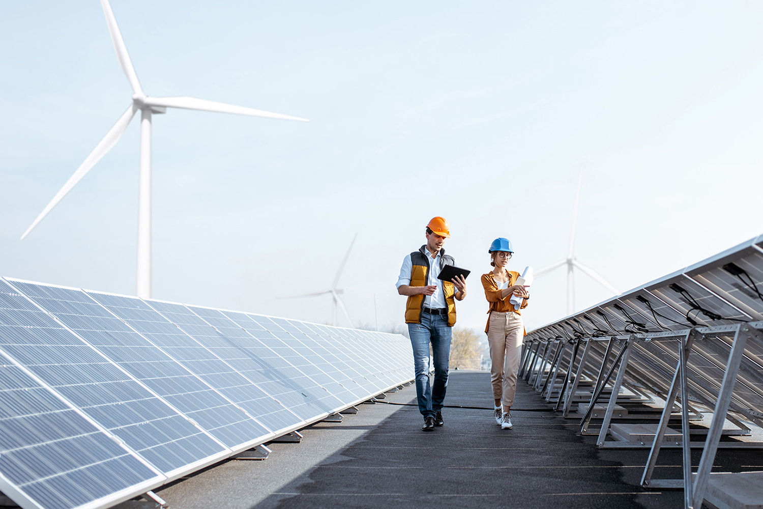 dos operarios entre placas solares y molinos de viento