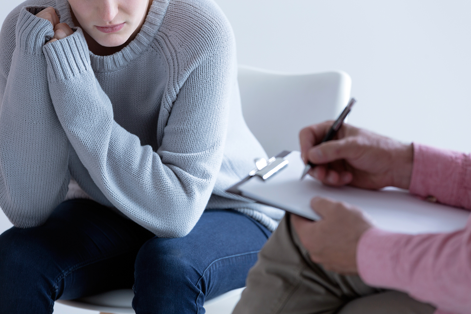 un psicólogo toma nota en la consulta con un cliente víctima de violencia