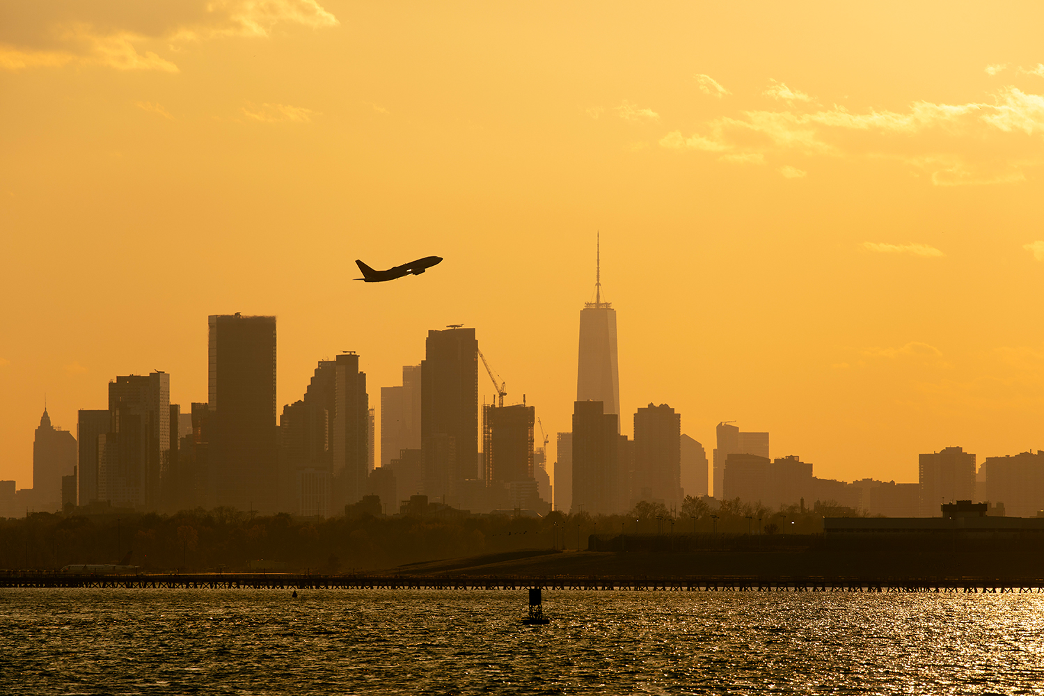 Un avión despega de Nueva York con el icónico skyline de la ciudad estadounidense al fondo