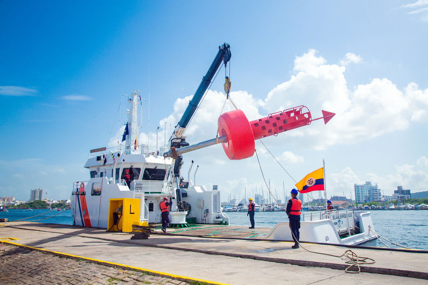 un barco opera una boya marina guía en un puerto de Colombia