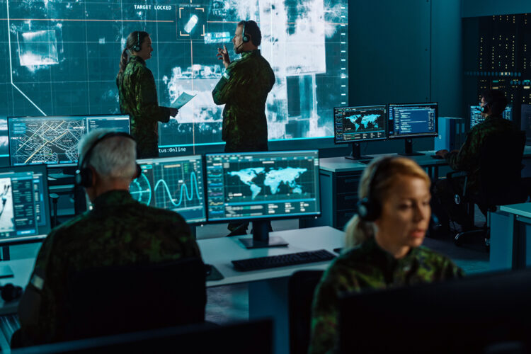 militares en una sala de control con monitores y un videowall