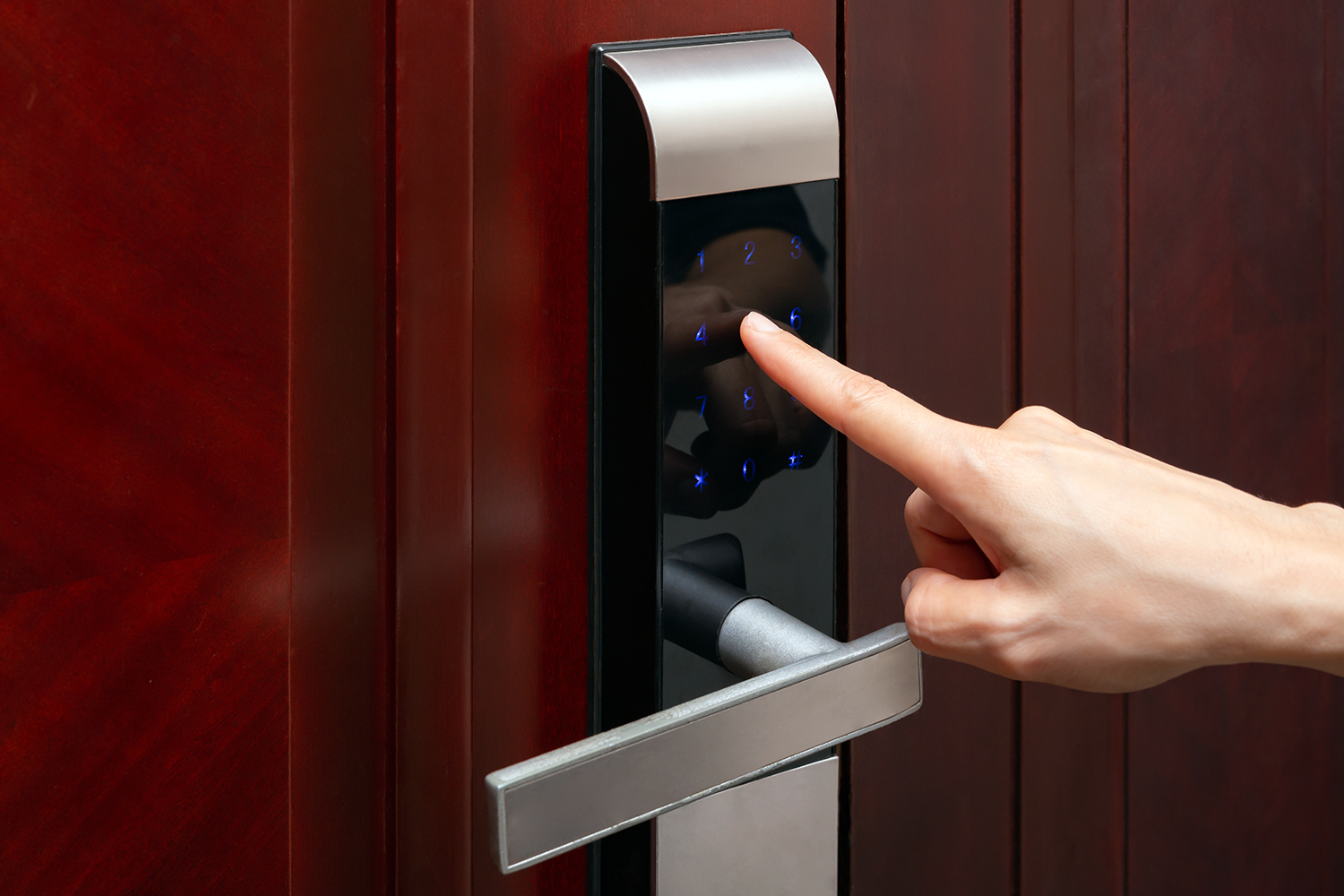 una persona intenta abrir una puerta con cerradura de teclado numérico