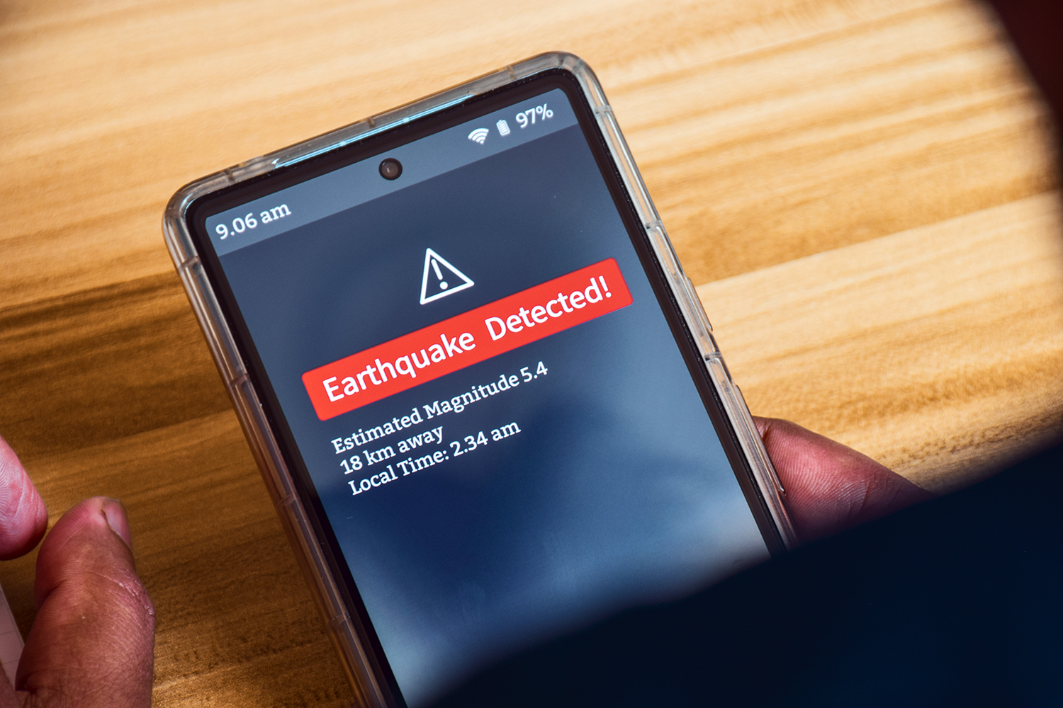 un hombre recibe una notificación de alerta de terremoto en su smartphone