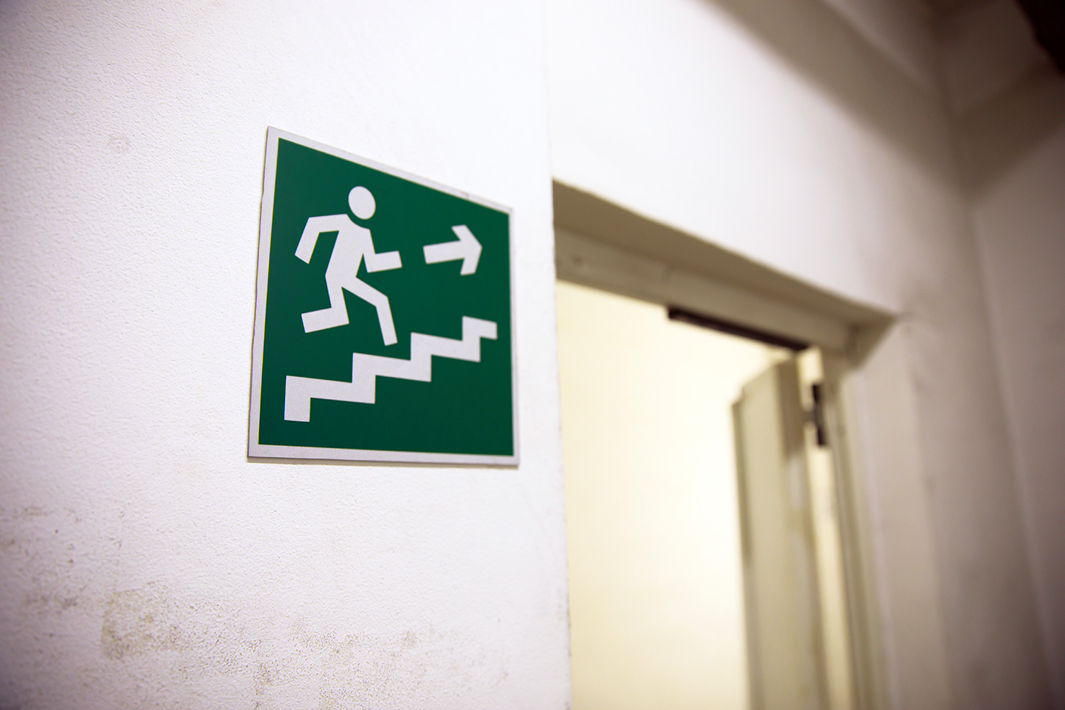 una señal de escalera de emergencia junto a una puerta en el interior de un edificio